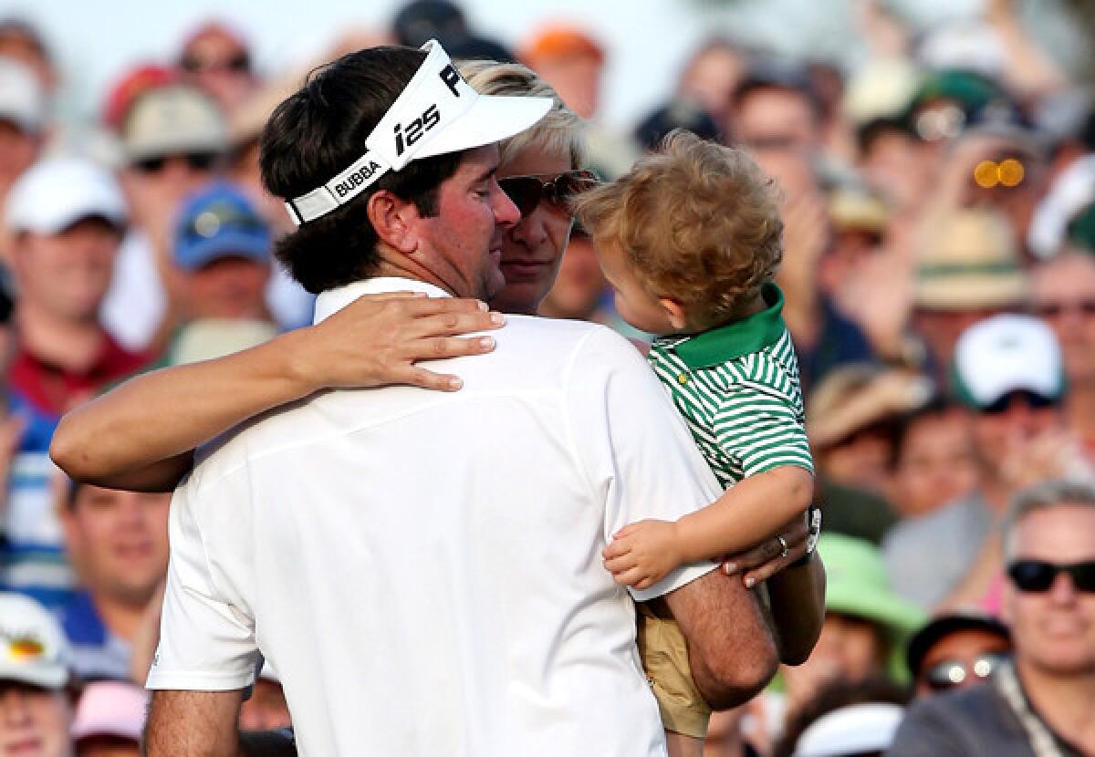 Bubba Watson celebrates with wife Angie and son Caleb next to the 18th green after winning the Masters tournament on Sunday at Augusta National Golf Club.