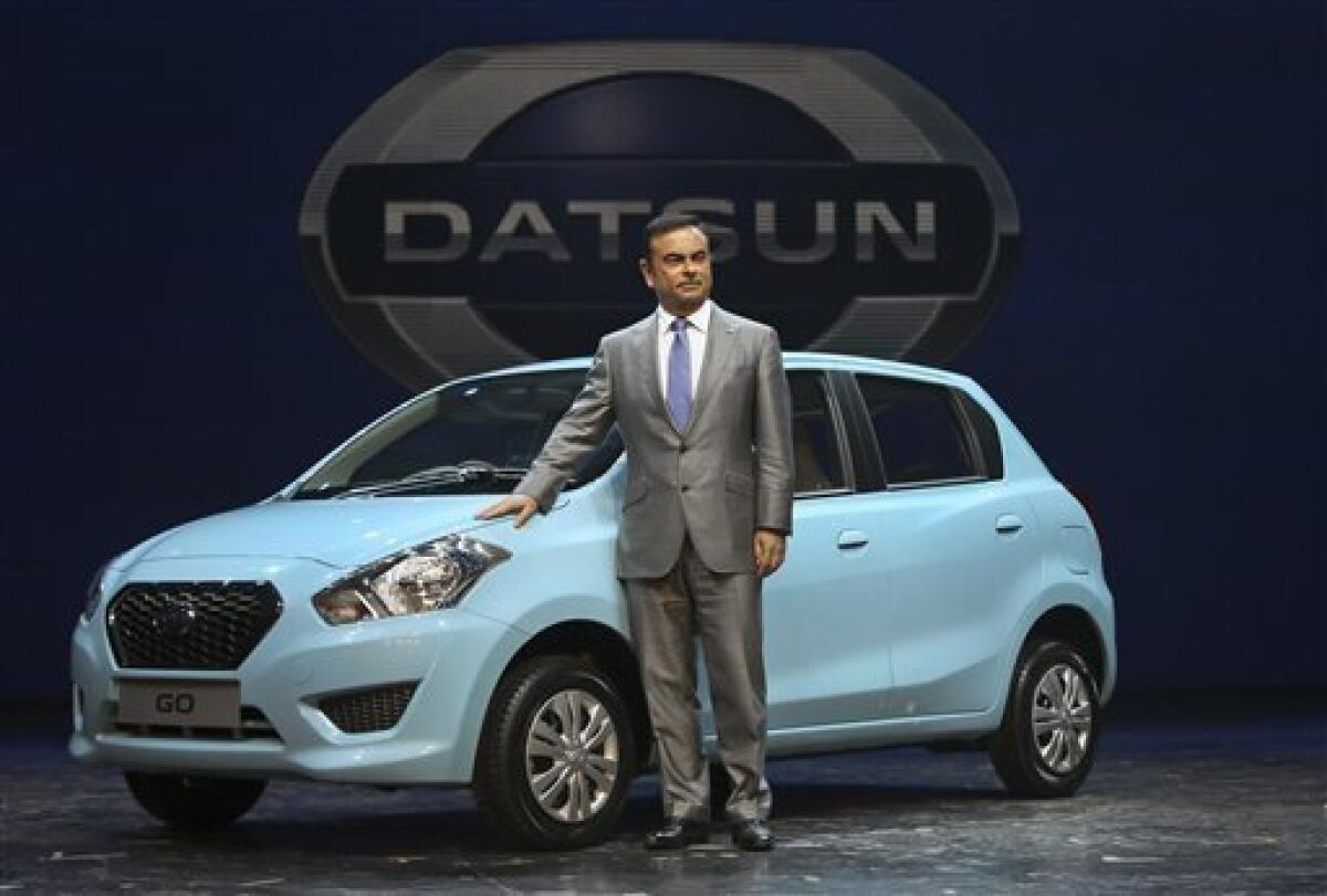 Nissan Motor Co. President and CEO Carlos Ghosn poses for the media with Datsun Go during its global launch in New Delhi, India, Monday, July 15, 2013. Nissan has introduced the first new Datsun model in more than three decades in the Indian capital. The company hopes bringing back the brand that built its U.S. business will fuel growth in emerging markets with a new generation of car buyers. The reimagined Datsun - a five-seat hatchback - will go on sale in India next year for under 400,000 rup