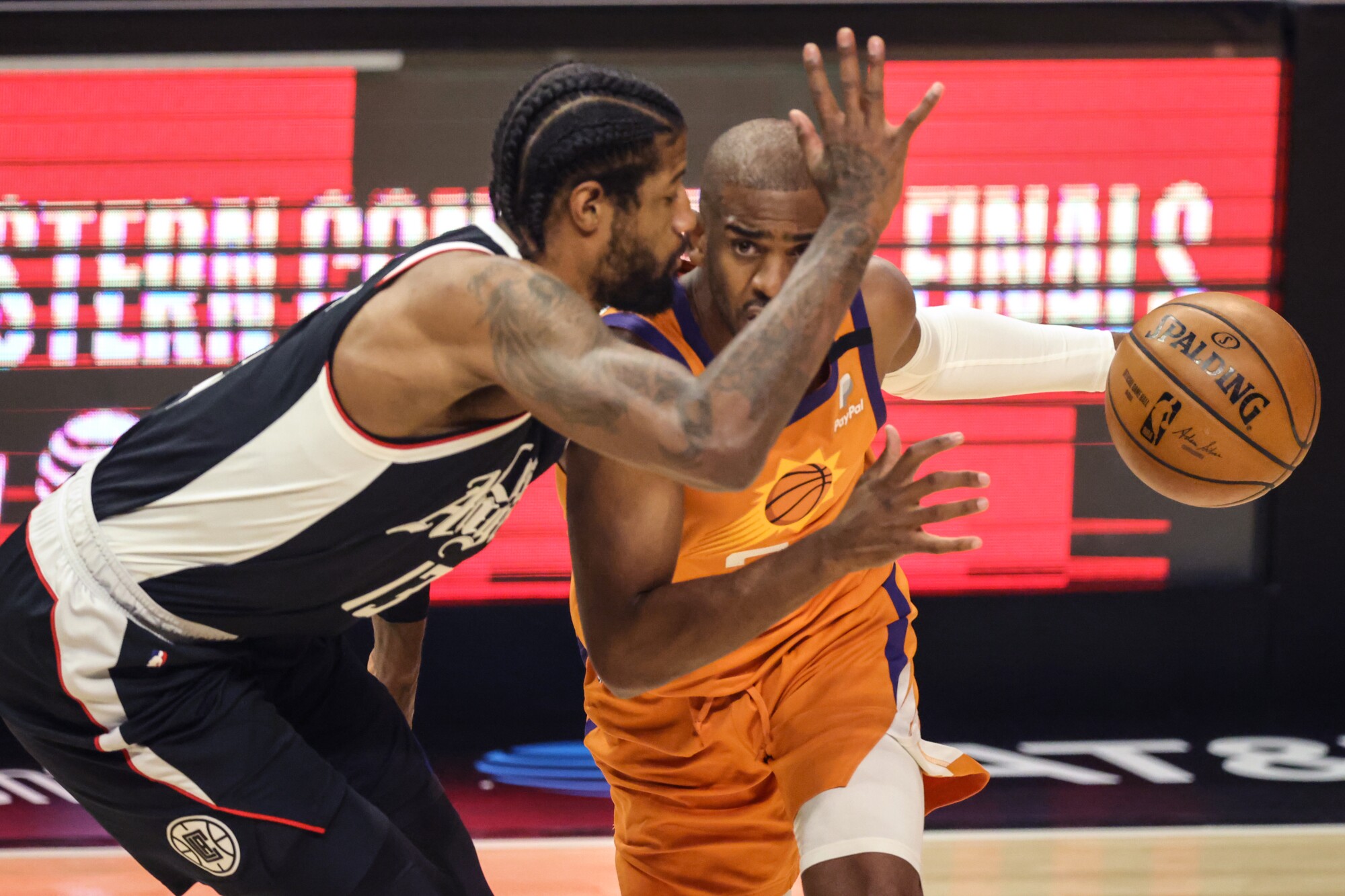 Clippers forward Paul George closely defends Suns guard Chris Paul during the first half of Game 3.