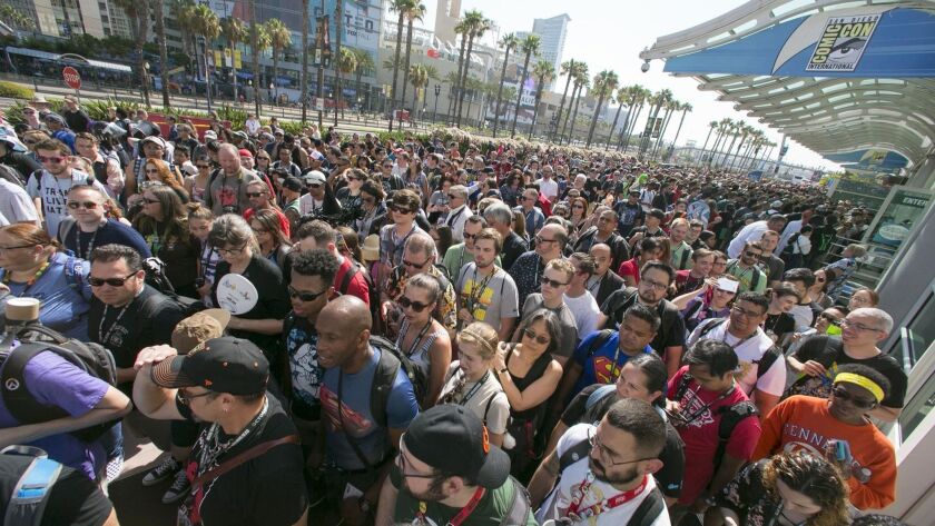 People wait to get in to one of the entrances to the exhibit halls at the convention center for Comic-Con 2018.