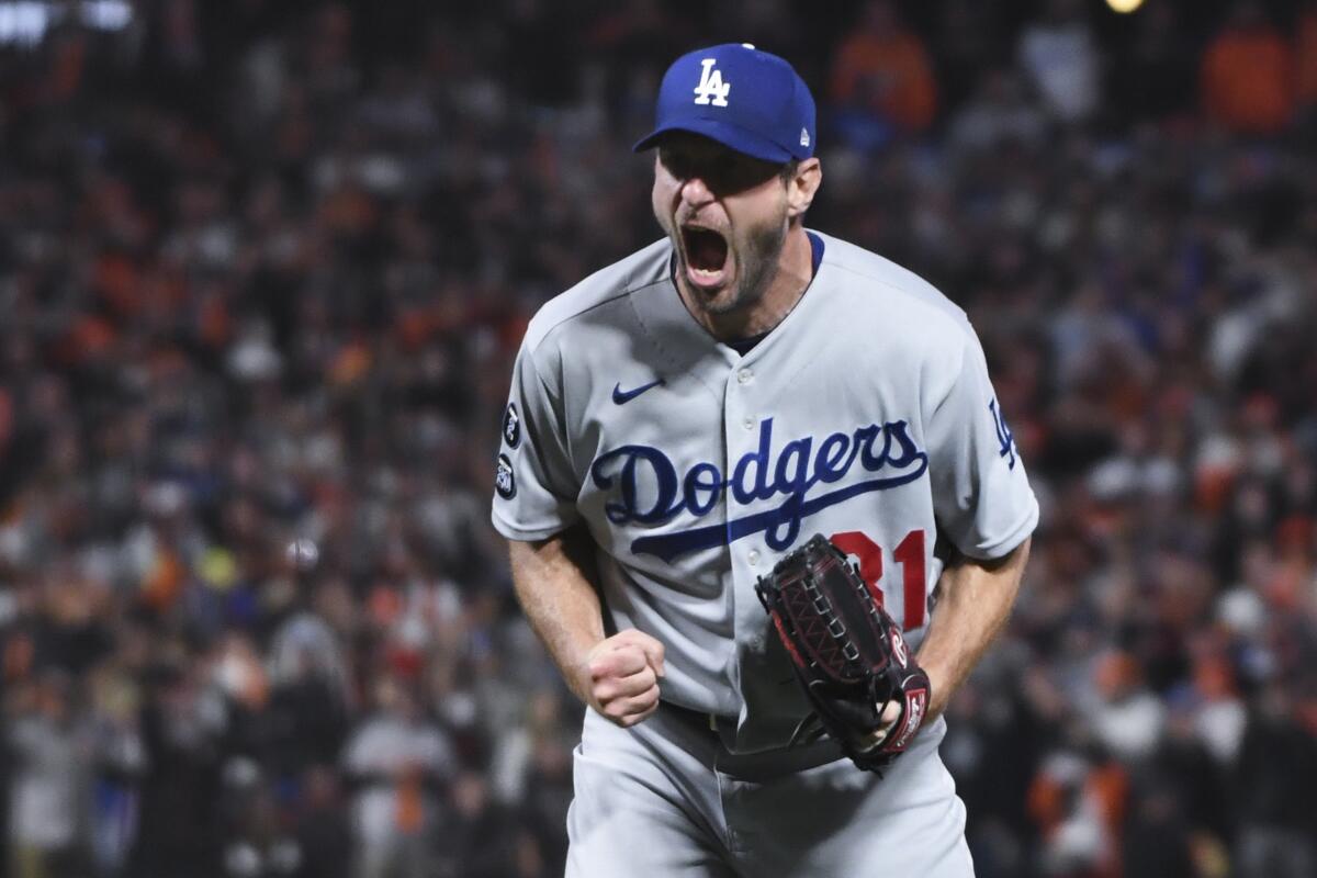 Max Scherzer reacts after striking out the Giants' Wilmer Flores to wrap up the Dodgers' 2-1 win Oct. 14.