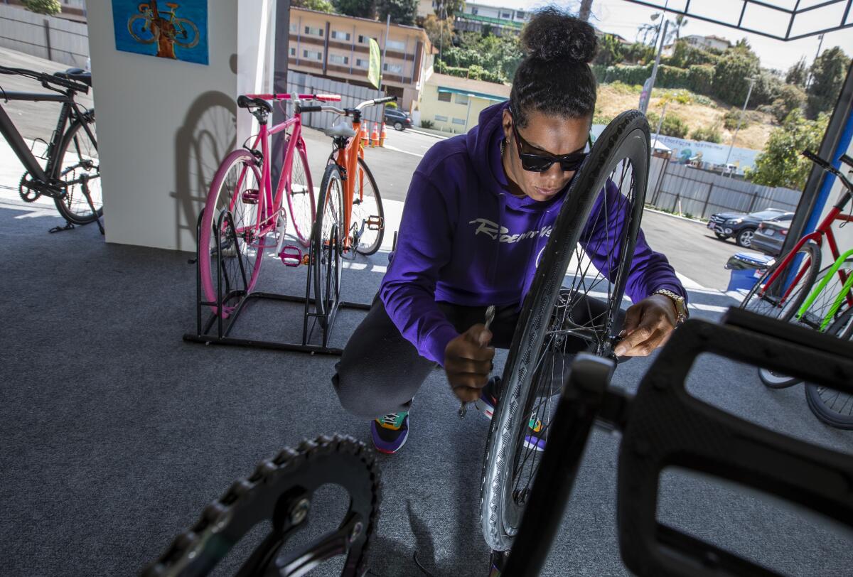 Kellie Hart tightens the front wheel on a bike