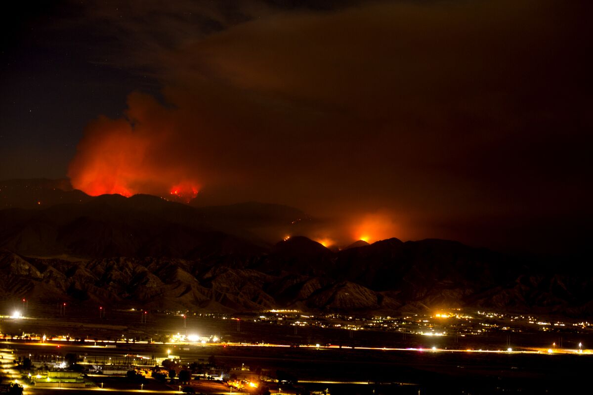 The Apple Fire burns behind mountains near Beaumont, Calif., Sunday, Aug. 2, 2020. (AP Photo/Ringo H.W. Chiu)