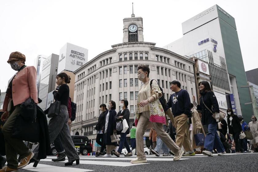 FILE - People walk across a pedestrian crossing in Ginza shopping district in Tokyo on March 31, 2023. The Japanese economy shrank at an annual rate of 2% in the first quarter of this year, as consumption and exports declined, the government said Thursday, May 16, 2024. (AP Photo/Eugene Hoshiko, File)