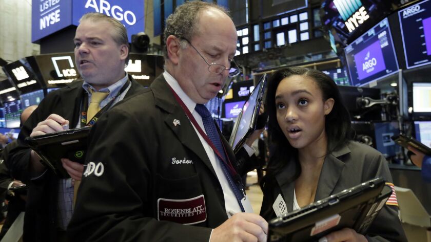 Trader Gordon Charlop confers with colleague Lauren Simmons on the floor of the New York Stock Exchange.