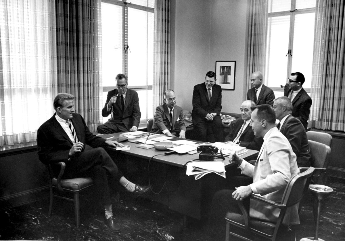 A group of men sit around a desk in an old Los Angeles Times office