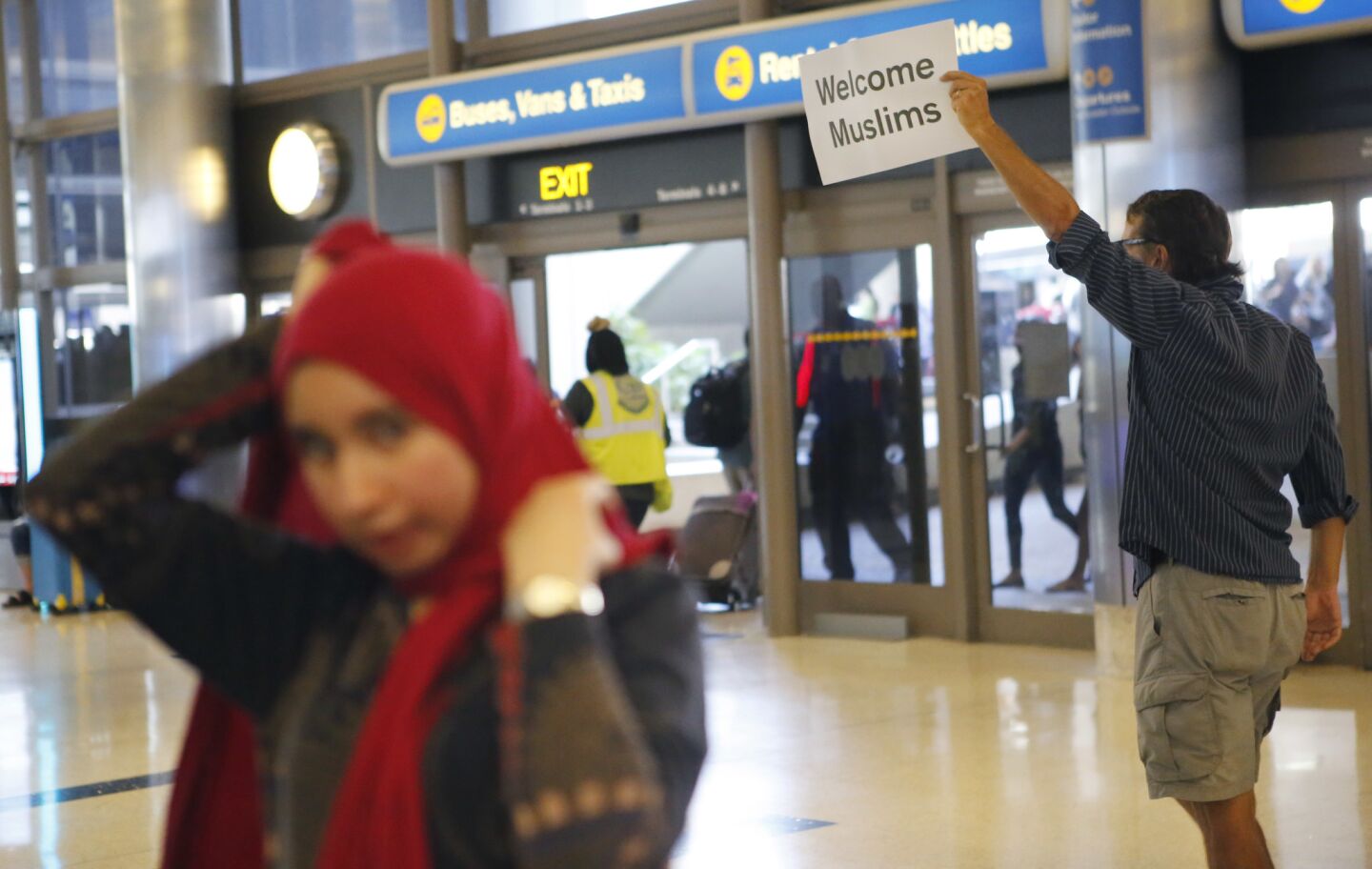 John Wilder holds a sign welcoming Muslims to the United States at Tom Bradley International Terminal.