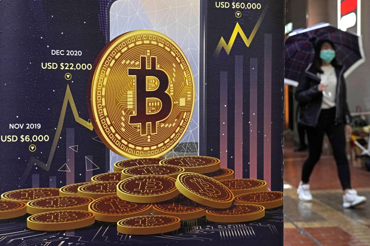 FILE - An advertisement for Bitcoin cryptocurrency is displayed on a street in Hong Kong, Thursday, Feb. 17, 2022. Britain has unveiled plans to regulate some stablecoins as part of a broader plan to become a global hub for digital payments, as authorities in the U.S. and Europe race to draw up rules for cryptocurrencies. The British Treasury said Monday, April 4, 2022, that it would also work with the Royal Mint to create a digital collectible known as an NFT and introduce a set of measures aimed at attracting cryptocurrency companies. (AP Photo/Kin Cheung, File)
