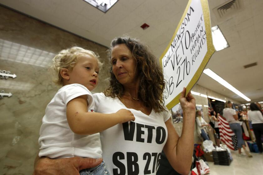 Kim Whitley holds her granddaughter Kole, 3, as she joins other opponents of the recently passed legislation to tighten the rules on giving exemptions for vaccinations In a demonstration in front of Gov. Gavin Newsom's Capitol office in Sacramento, Calif., Monday, Sept. 9, 2019. Newsom signed the bill, SB 276 by Sen. Richard Pan, D-Sacramento, Monday. (AP Photo/Rich Pedroncelli)