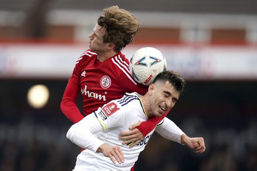Accrington Stanley's Tommy Leigh and Leeds United's Marc Roca, front, battle for the ball during the English FA Cup fourth round soccer match at the Wham Stadium, Accrington, England, Saturday Jan. 28, 2023. (Mike Egerton/PA via AP)