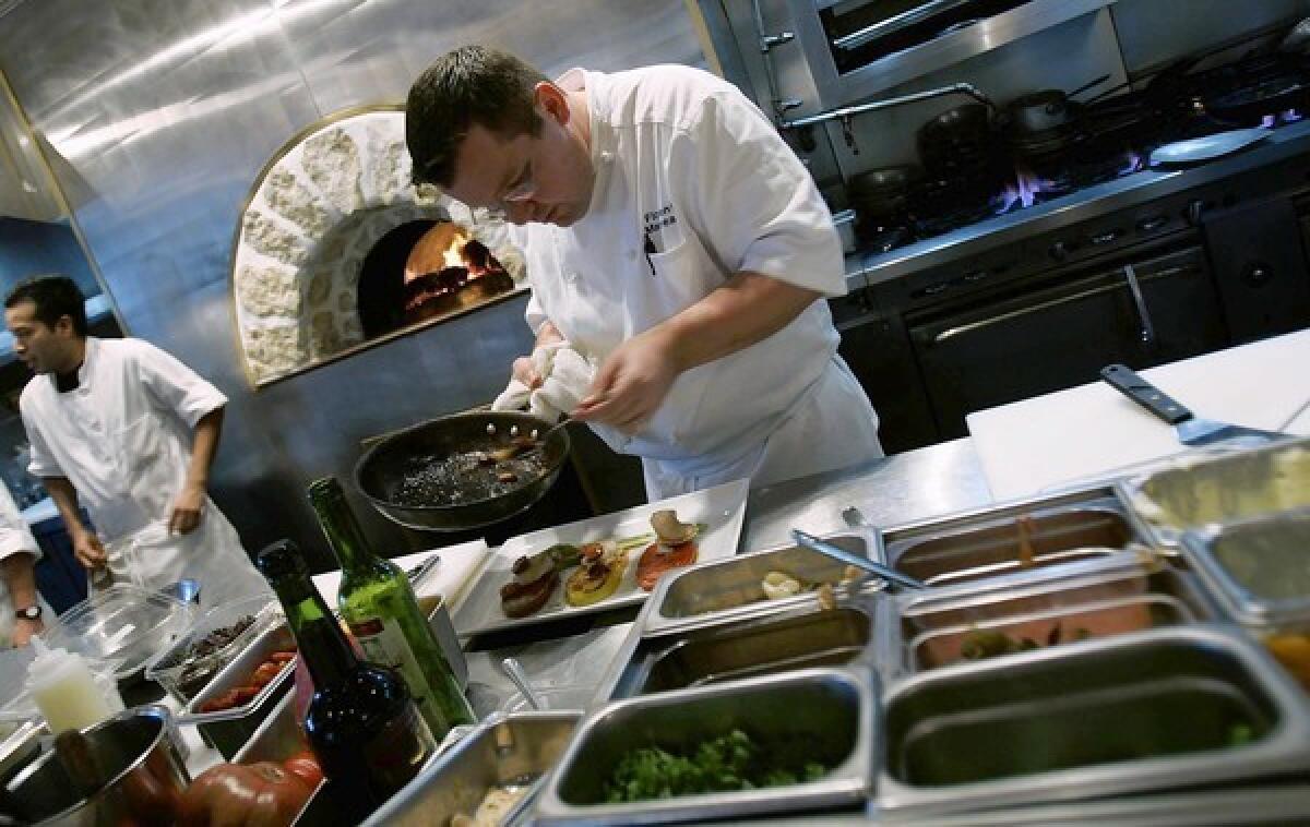 Chef and owner Florent Marneau prepares a dish in the open kitchen at Marche' Moderne in Costa Mesa at South Coast Plaza.