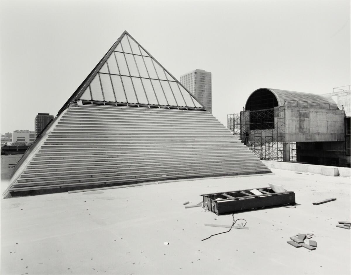 A vintage print shows a pyramid skylight in the foreground, with a barrel vault, surrounded by scaffolding, in the back.