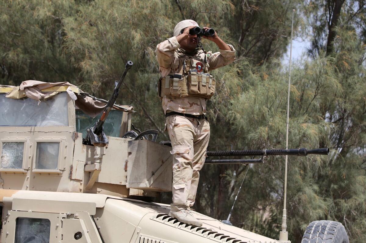 A member of the Iraqi forces checks the horizon during a recent patrol west of Baghdad. U.S. officials are considering training Iraqi troops to act as ground controllers for airstrikes.