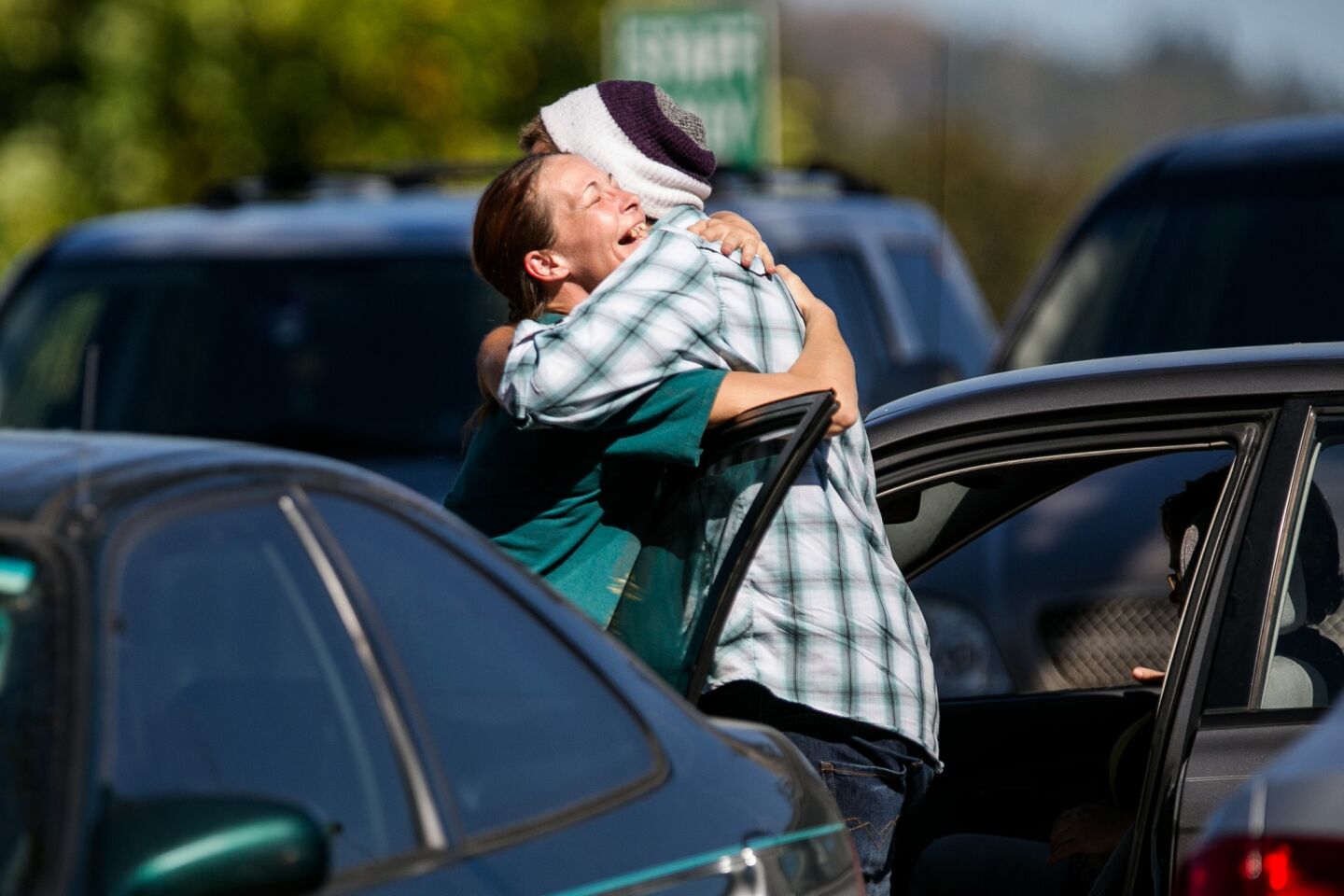 Mathew Downing, right, a survivor of the Umpqua Community College mass shooting, gets a hug as soon as he arrives back on campus.