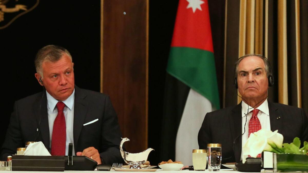 Jordanian King Abdullah II, left, and then-Prime Minister Hani Mulki attend an official lunch meeting at the royal palace in Amman on May 1, 2018.