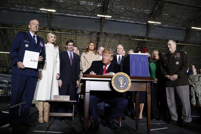 President Donald Trump signs the National Defense Authorization Act for Fiscal Year 2020 at Andrews Air Force Base, Md., Friday, Dec. 20, 2019. (AP Photo/Andrew Harnik)