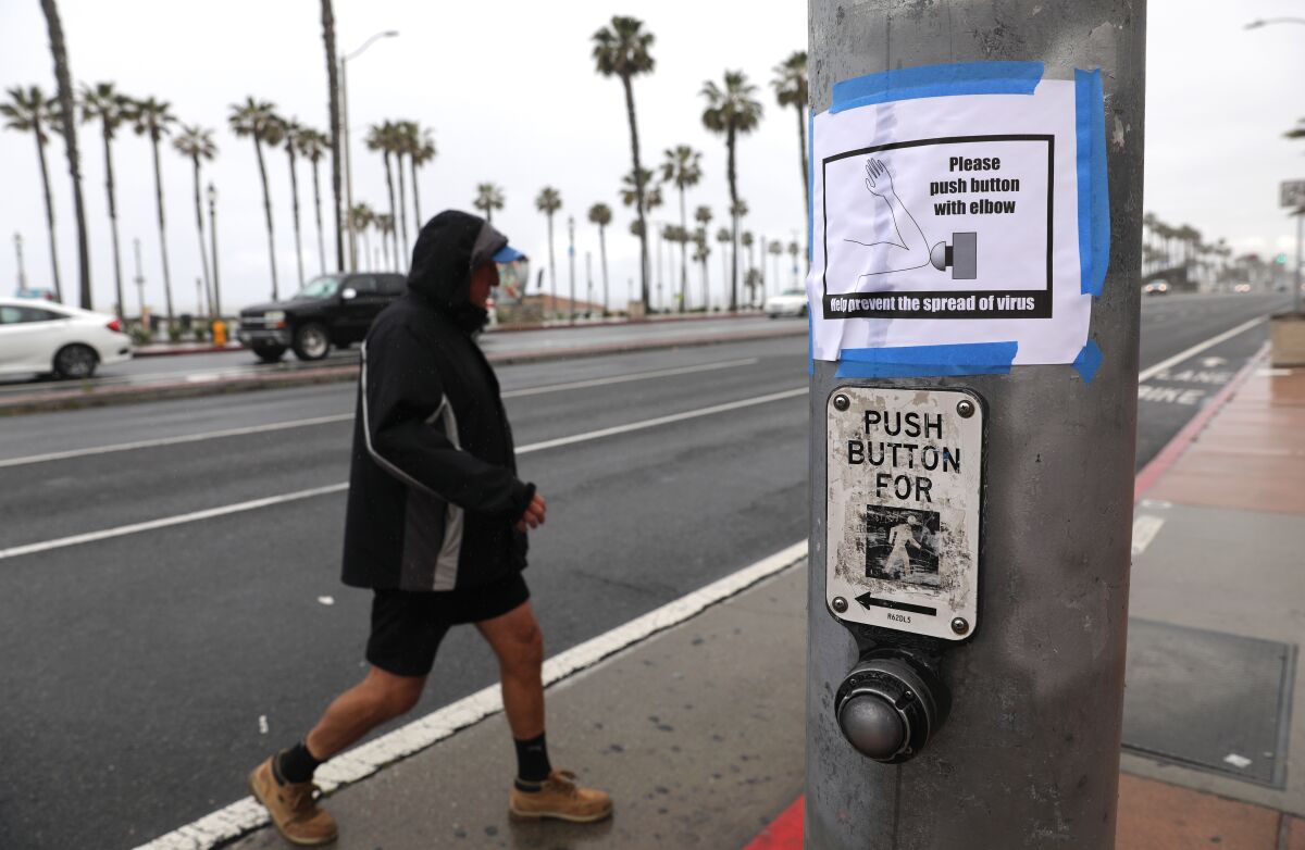 A crosswalk sign posted at the intersection of Pacific Coast Highway and Main Street in Huntington Beach.