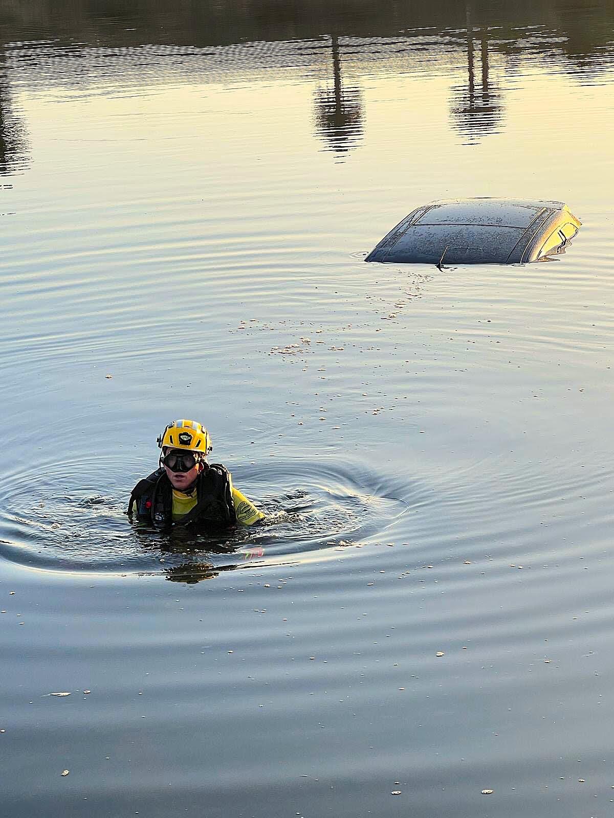 A marine safety specialist works at the scene of a crash near PCH and Warner Avenue in Huntington Beach.
