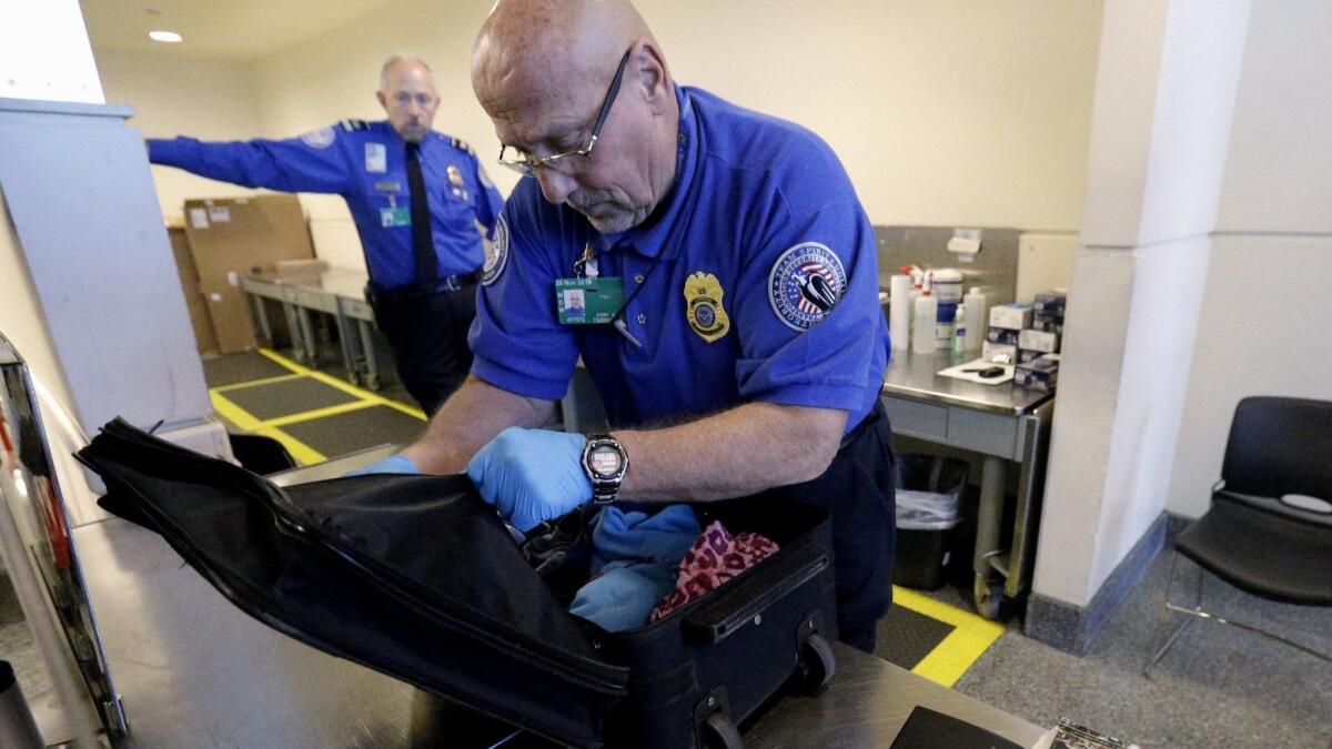 A Transportation Security Administration agent checks a bag at Midway International Airport in Chicago.