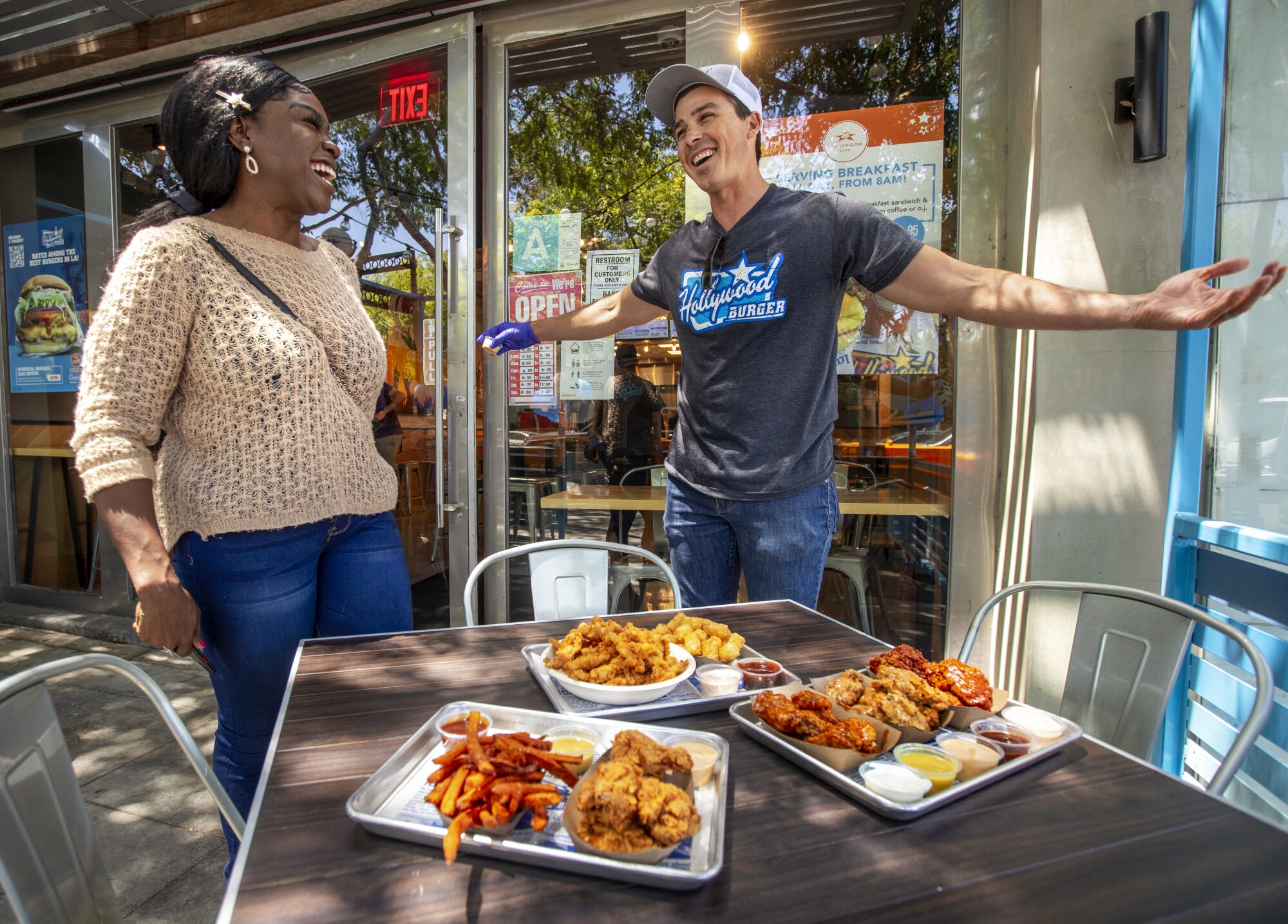 Nkechi Ahaiwe smiles after having her food order delivered to a table at Hollywood Burger by Kevin Shea.