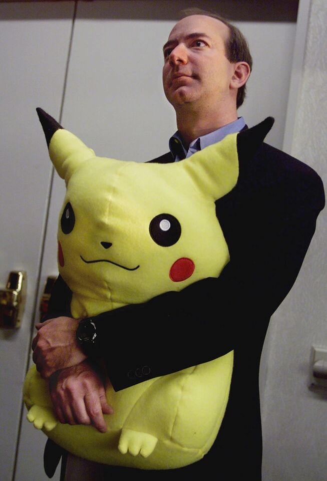 Jeff Bezos, founder and CEO of Amazon.com, holds a large, stuffed Pikachu Pokemon doll as he listens to comments at a New York news conference, Tuesday Nov. 9, 1999.