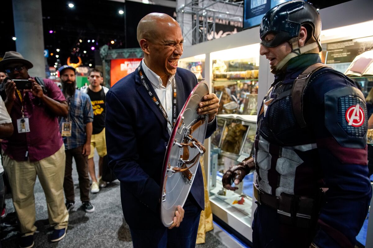 Presidential candidate Sen. Cory Booker talks with John Vash, cosplaying as "Captain America," while holding his shield at Comic-Con International.