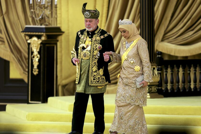 El 17mo rey de Malasia, Sultan Ibrahim Iskandar, y la reina Raja Zarith Sofiah, se acercan al trono durante su coronación, en el Palacio Nacional, en Kuala Lumpur, Malasia, el 20 de julio de 2024. (Hasnoor Hussain/Pool Foto vía AP)