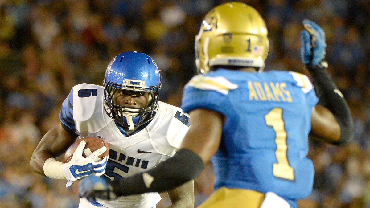 Memphis wide receiver Mose Frazier runs after making a catch in front of UCLA defensive back Ishmael Adams during the Bruins' win Saturday.