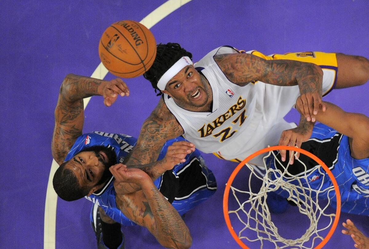 Lakers power forward Jordan Hill battles Magic forward Kyle O'Quinn battle for a rebound.