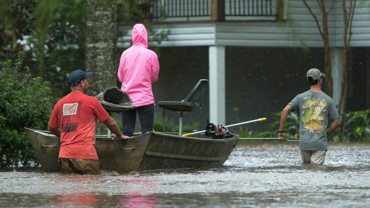 Residents use boats to retrieve people and items from flooded homes Aug. 29 in Moss Bluff, La.