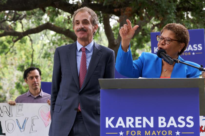 Los Angeles, CA - May 17: Karen Bass takes the microphone after Mike Feuer, left, publicly drops out of the mayoral race to endorse Bass at the Encino Park on Tuesday, May 17, 2022 in Los Angeles, CA. (Dania Maxwell / Los Angeles Times)