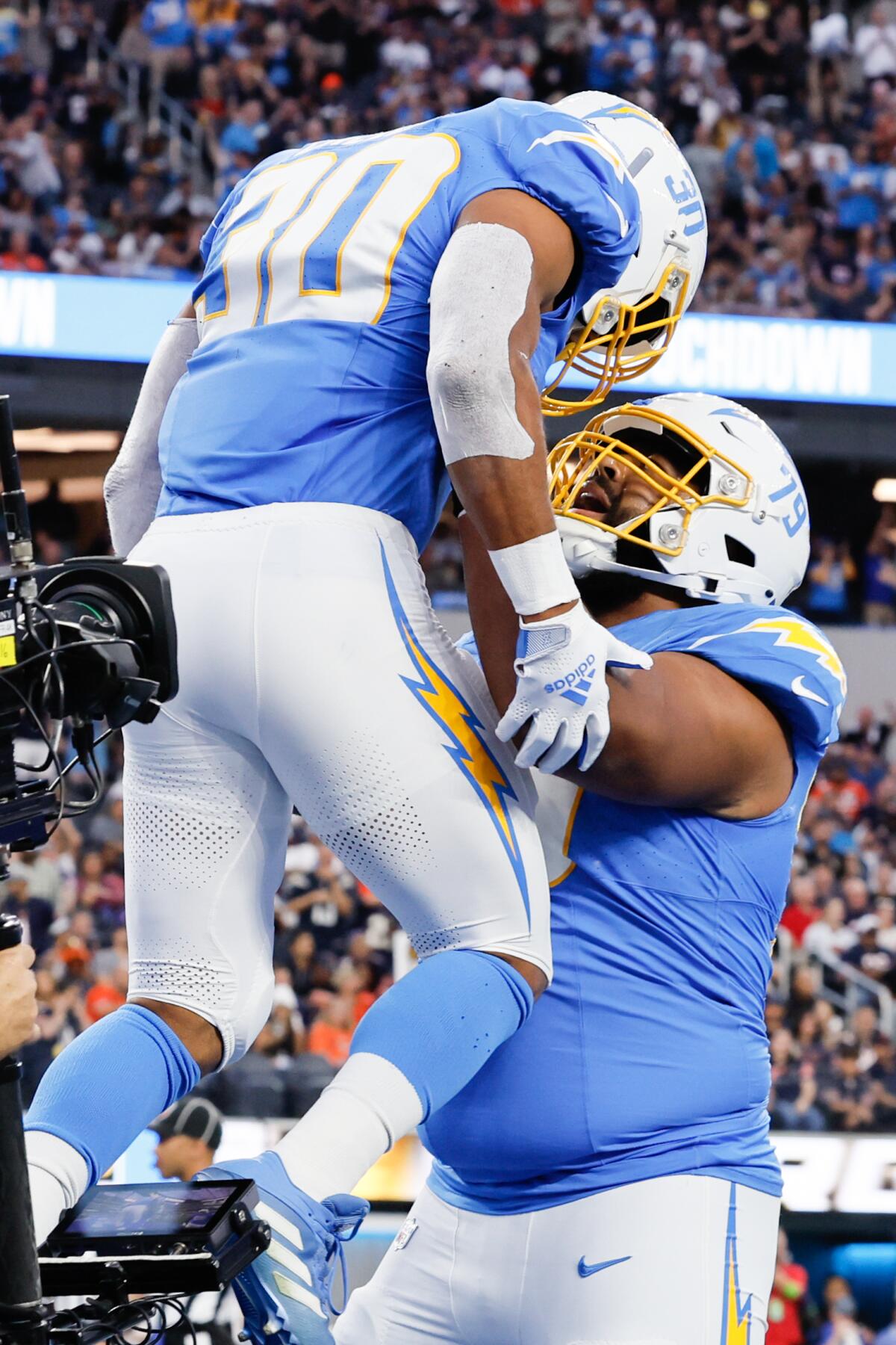 The Chargers' Trey Pipkins III (79) celebrates a 39-yard touchdown reception by Austin Ekeler (30) against the Bears.