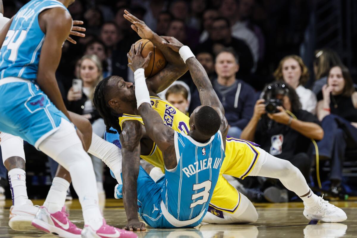 Lakers forward Taurean Prince, center, battles Charlotte Hornets guard Terry Rozier for a loose ball in the first half.