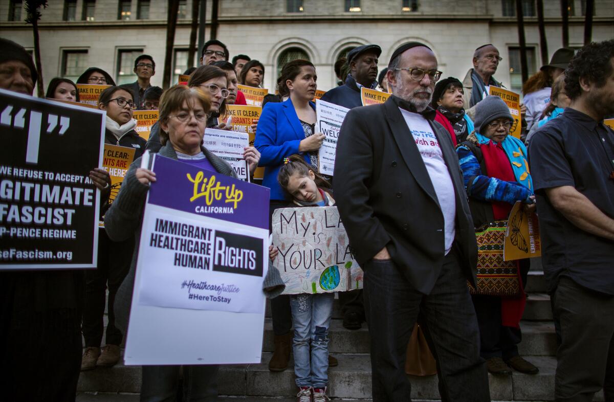 Maya Casillas, 7, middle, joins about 60 protesters for a vigil against President Donald Trump's executive orders on immigration at City Hall in Los Angeles on Wednesday.