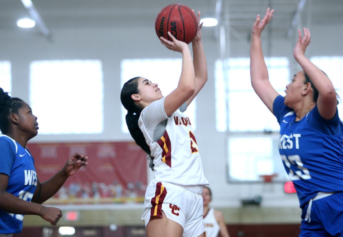 Glendale Community College's Zoe Rouse takes a jumper in between two defenders against West Los Angeles College during Saturday's home conference game.