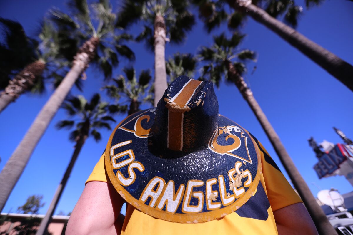 A Los Angeles Rams sombrero hangs on the back of a parade attendee