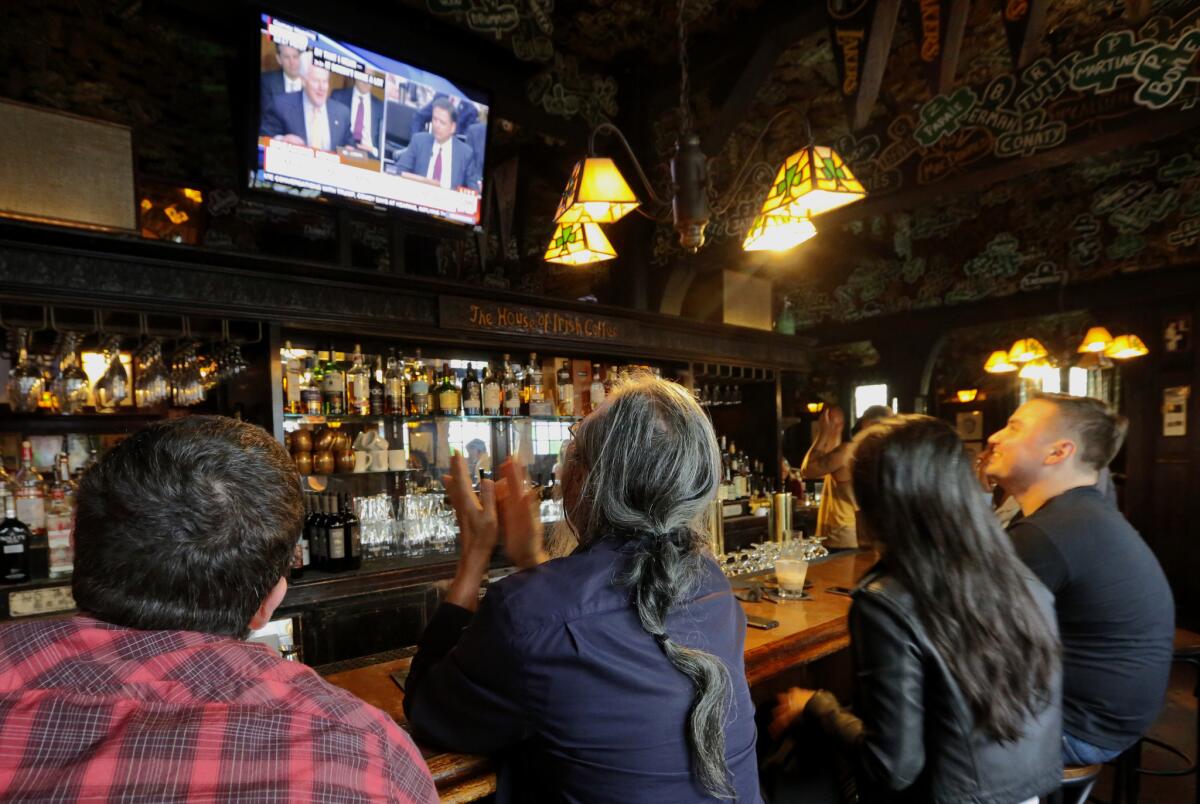 Patrons in Tom Bergin's Public House in Los Angeles watch the Comey testimony at the bar.