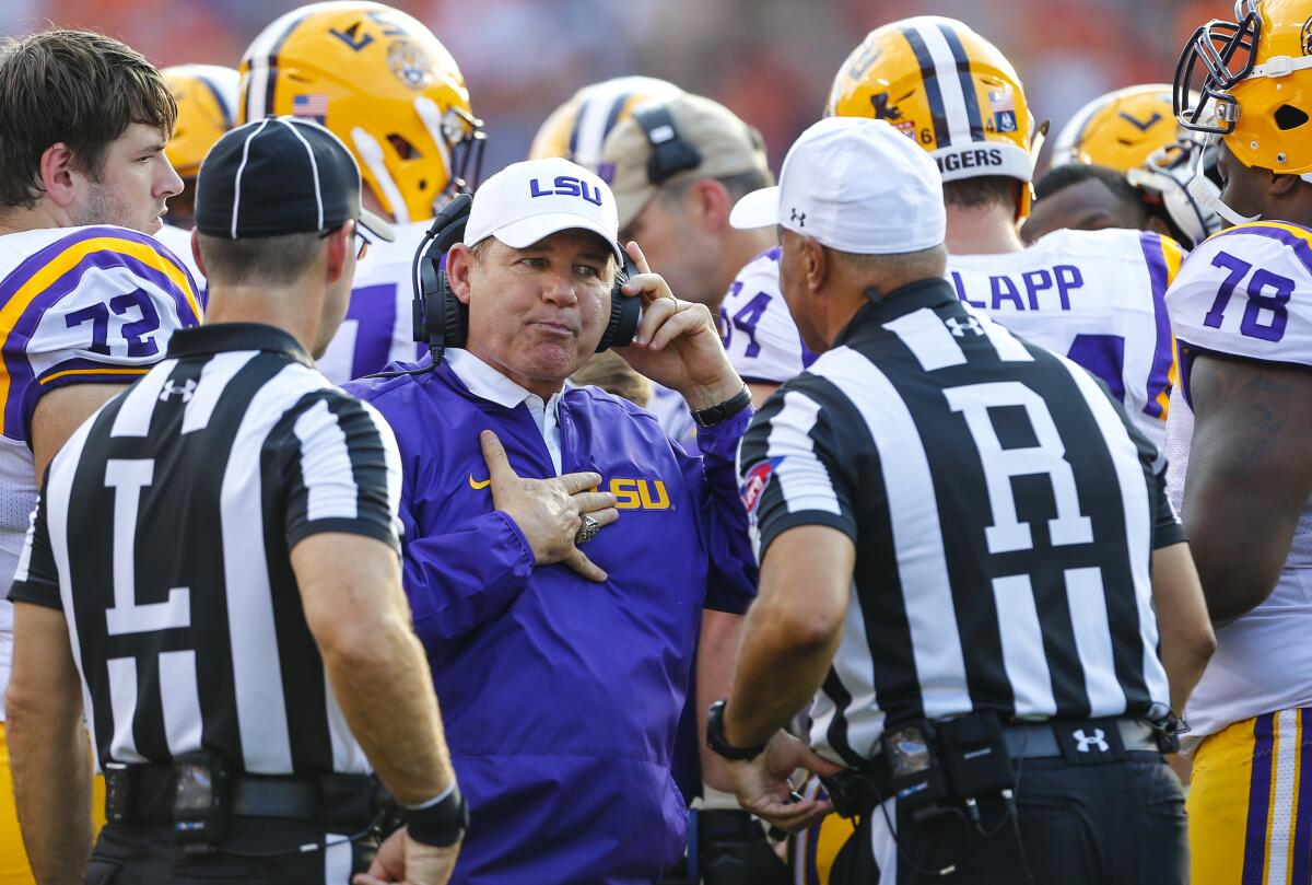 FILE - Then-LSU head coach Les Miles talks with referees during the first half of an NCAA college football game against Auburn in Auburn, Ala., in this Saturday, Sept. 24, 2016, file photo. Then-Athletic Director Joe Alleva's recommendation to former LSU President F. King Alexander is detailed in a newly released report into how the university handled sexual misconduct complaints. The exhaustive report released Friday, March 5, 201, by the Husch Blackwell law firm, offers a scathing view of the resources and attention LSU has dedicated to such complaints and has resulted in the suspensions of two senior officials in the athletic department. (AP Photo/Butch Dill)