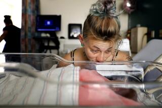 Mckenzie Trahan, 23, keeps an eye on her newborn daughter Ann at Adventist Health White Memorial in Boyle Heights. (Christina House / Los Angeles Times)