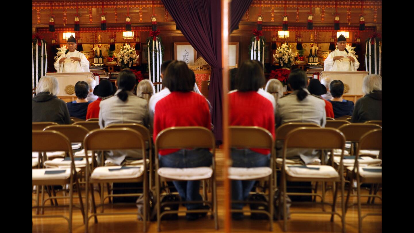 Congregants, reflected in a nearby mirror, listen as the Rev. Alfred Tsuyuki, 73, head minister of Konko Church of Los Angeles, presides over the monthly Mitama service which honors the dead.