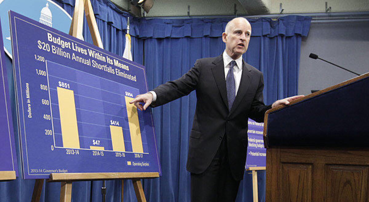 Gov. Jerry Brown points to a chart showing an increase in education funding in his proposed 2013-14 state budget during a January news conference.
