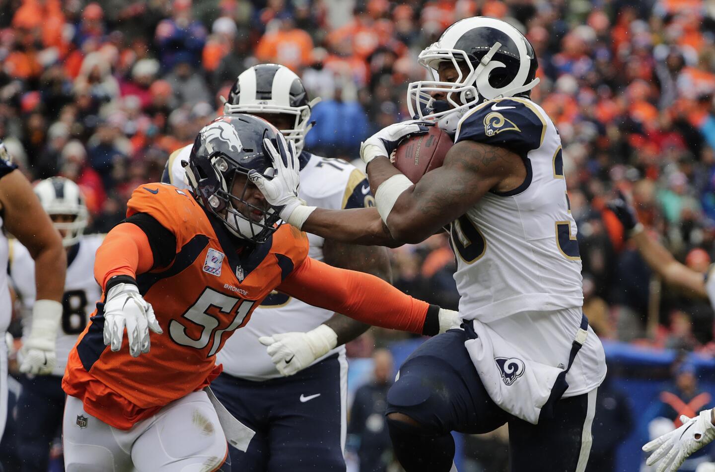 Rams running back Todd Gurley (30) keeps his hand on Denver Broncos linebacker Todd Davis (51) as he scores on a 4th and 1 play from the 10 yard line in the second quarter at Broncos Stadium at Mile High on Sunday.