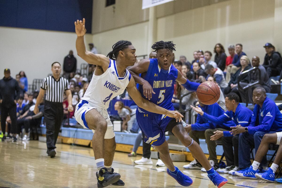 Fountain Valley's Jeremiah Davis drives to the baseline against Price's Josiah Wimberly during the quarterfinals of the CIF State Southern California Regional Division III playoffs on Thursday in Los Angeles.