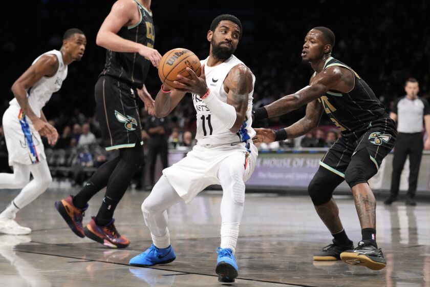 Brooklyn Nets guard Kyrie Irving (11) drives around Charlotte Hornets guard Terry Rozier (3) during the second half of an NBA basketball game, Wednesday, Dec. 7, 2022, in New York. (AP Photo/John Minchillo)