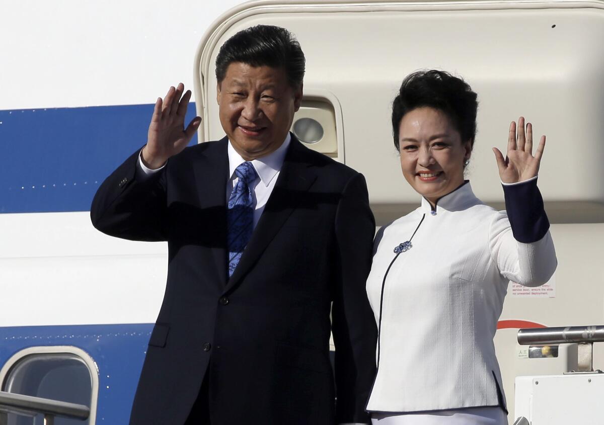 Chinese President Xi Jinping and his wife, Peng Liyuan, wave upon arrival at Boeing Field in Everett, Wash., on Sept. 22.