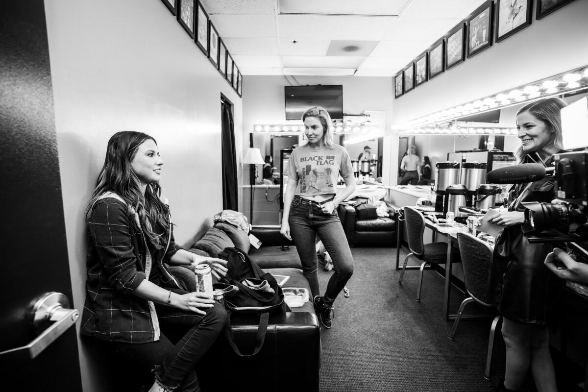 black and white photo of three women in a dressing room 