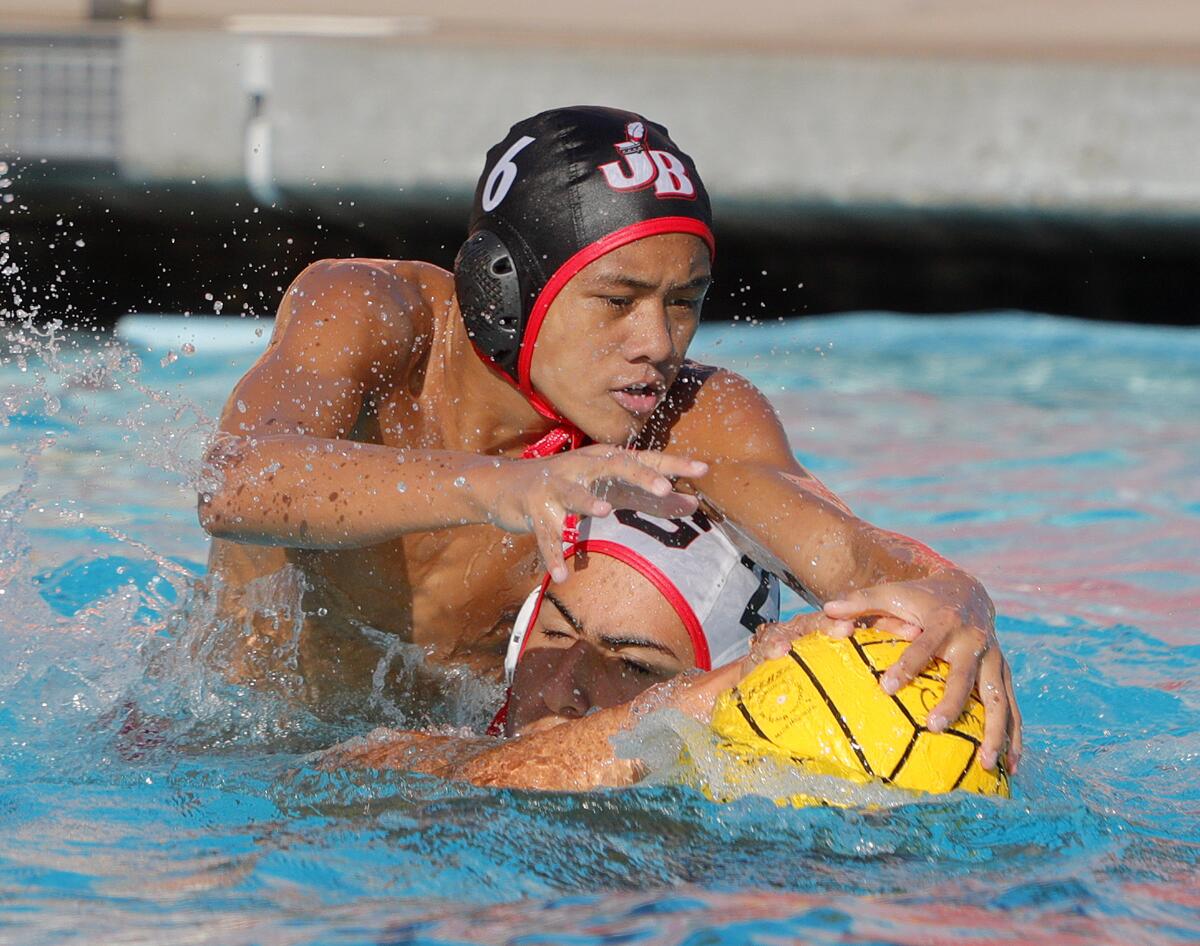 Burroughs' Xavier Turla goes over the top of Glendale's Levon Chaglasian and is called for a penalty in a Pacific League boys' water polo match at Burroughs High School on October 1, 2019. Glendale won the match 10-8.