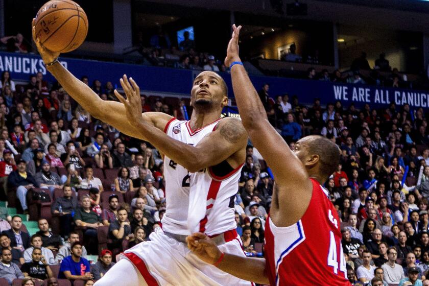 Forward Chuck Hayes challenges a shot by Raptors guard Norman Powell during a Clippers preseason game on Oct. 4.