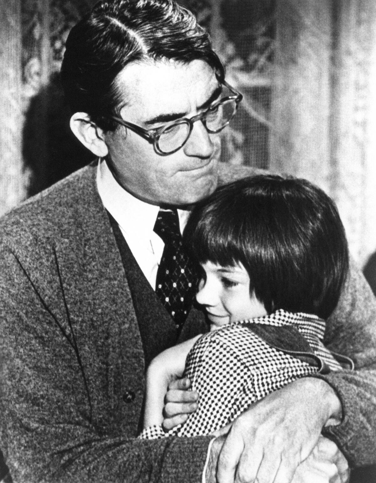 Gregory Peck embraces Mary Badham, 9, a Birmingham, Ala. acting discovery who plays his daughter in “To Kill a Mockingbird."