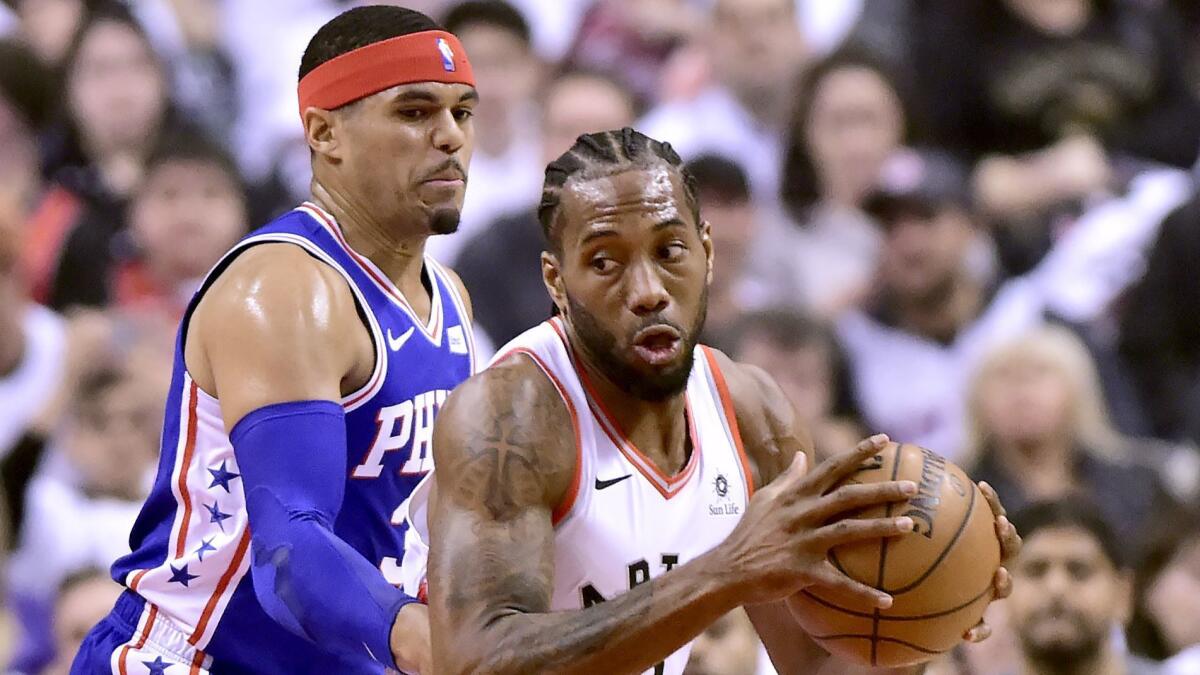 Philadelphia 76ers forward Tobias Harris, left, watches as Toronto Raptors forward Kawhi Leonard (2) moves the ball during the first half of Game 1 of a second-round NBA playoff series in Toronto on Saturday.